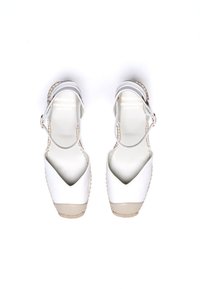 Sandalias de esparto blancas con punta en forma de V, tira en el tobillo y acentos beige. Presentan un ribete de yute trenzado y parte superior de cuero suave.