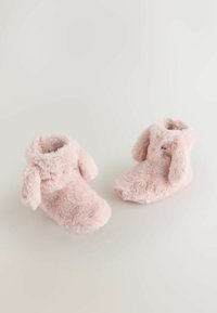 Rozā, pūkainas zābaciņas ar mīkstu tekstūru. Iesūkšanas ausis un noapaļota forma, kas paredzēta komfortam un siltumam. Nav redzamu aizdaru.
