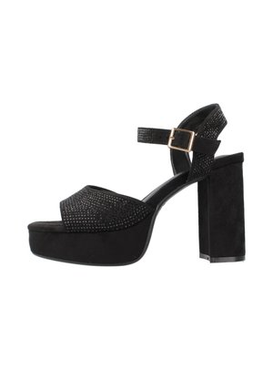 Sandalias de plataforma negras con una amplia correa frontal que presenta embellishments de rhinestones y una correa al tobillo con hebilla. Material de ante texturizado.