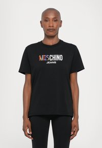 Juodas trumpas rankovėmis marškinėliai su spalvingu "Mitchino" logotipu ir "JEANS" tekstu, pagaminti iš minkštos medžiagos, turintys laisvą siluetą.