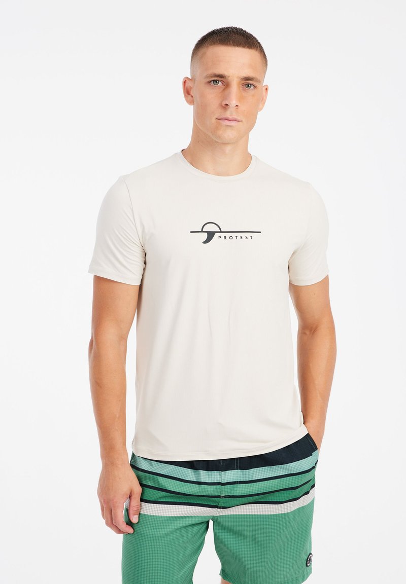 Lichtbeige korte mouw t-shirt van zachte stof, met een zwart grafisch logo op de borst. Gecombineerd met groene gestreepte zwembroek.