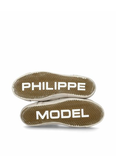 Suola di sneaker in beige chiaro con un motivo a spina di pesce testurizzato. Presenta il marchio bianco "PHILIPPE MODEL" e "MODEL" in caratteri in grassetto.