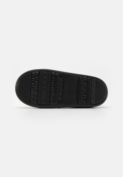 Talpa de pantof din cauciuc negru cu modele texturate pentru aderență. Prezintă un design circular și liniar pentru tracțiune. Suprafața este netedă în ansamblu.