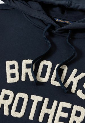 Hoodie bleu marine avec un logo en ivoire texturé "BROOKS BROTHERS", cordons de serrage bleu marine ajustables et un tissu doux en mélange de coton.