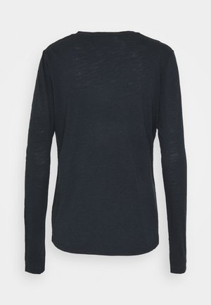 Majica s dugim rukavima, okruglog izreza u tamnoplavoj boji. Izrađena od lagane tkanine s lagano teksturiranim završetkom. Ravnoga kroja, bez vidljivih ukrasa.