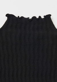 Haut noir à côtes avec un col ondulé et festonné. Fabriqué dans un tissu texturé, il présente des lignes verticales et une coupe ajustée.