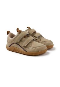 Chaussures beiges avec deux sangles ajustables en Velcro, semelle en caoutchouc texturée, tige en cuir lisse et une subtile ligne d'accent sombre.