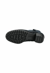 Bota de ante negra con suela de goma texturizada. Presenta un tacón bajo y un patrón de tracción detallado para un mejor agarre. Detalles de acento en el lateral.