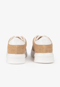 Zapatillas de yute marrón texturizadas con suelas y acentos de goma blanca. Forma redondeada y diseño con cordones que presenta un logotipo cosido en el talón.