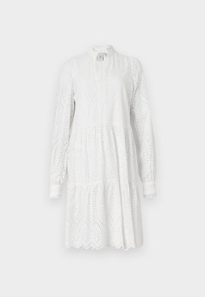 Valge pikkade varrukatega kleit, millel on augustikujundus, kõrge kaelus ja kihiline seelik. Omab sakilist ääre ja kerget kogumist vööl.