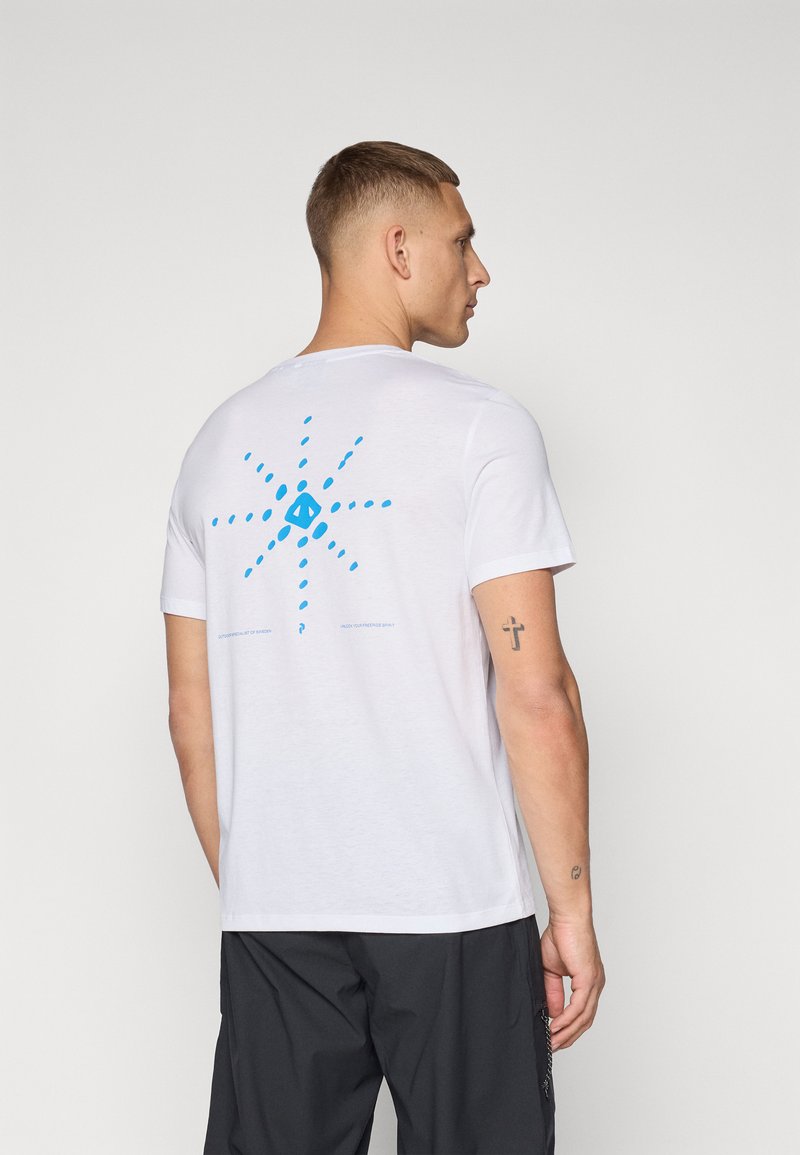 Camiseta de algodón blanca con un diseño gráfico de estallido de sol azul en la parte de atrás, con una textura suave y mangas cortas.