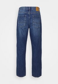 Džínové kalhoty v tmavém odstínu s rovnými nohavicemi. Zadní pohled ukazuje dvě našité kapsy a kožený štítek na pásku.