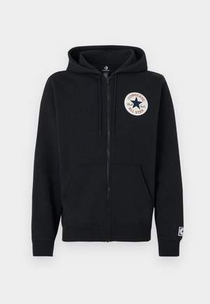 Musta vetoketjullinen huppari, valmistettu puuvillasta. Siinä on etutasku, resorireunaiset hihansuut ja vasemmassa rinnassa pyöreä logoplaatta. Pehmeä koostumus.