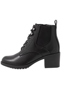 Botas de tobillo de cuero negro con puntera redondeada, parte delantera con cordones, paneles laterales elásticos y tacón de bloque apilado. Suela de goma duradera.