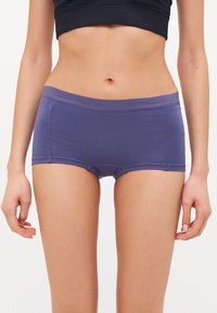 Lilla bomullsundertøy i kort stil med en glatt tekstur, elastisk midjebånd og sømløs design. Har et enkelt, minimalistisk utseende.