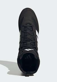 Czarny but sportowy z cholewką z siateczki i tkaniny, ozdobiony białymi paskami po bokach, z okrągłym noskiem i wzmocnionymi przelotkami na sznurówki.