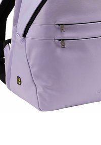 Zaino in pelle viola chiaro con una texture liscia, dotato di due tasche frontali con zip e una tracolla nera. Accento con logo in plastica sul lato.