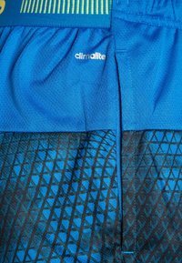 Blå idrottsshorts har ett lätt och ventilerande tyg med ett strukturerat geometriskt mönster i mörkare blått. Inkluderar Climacool-logotyp.