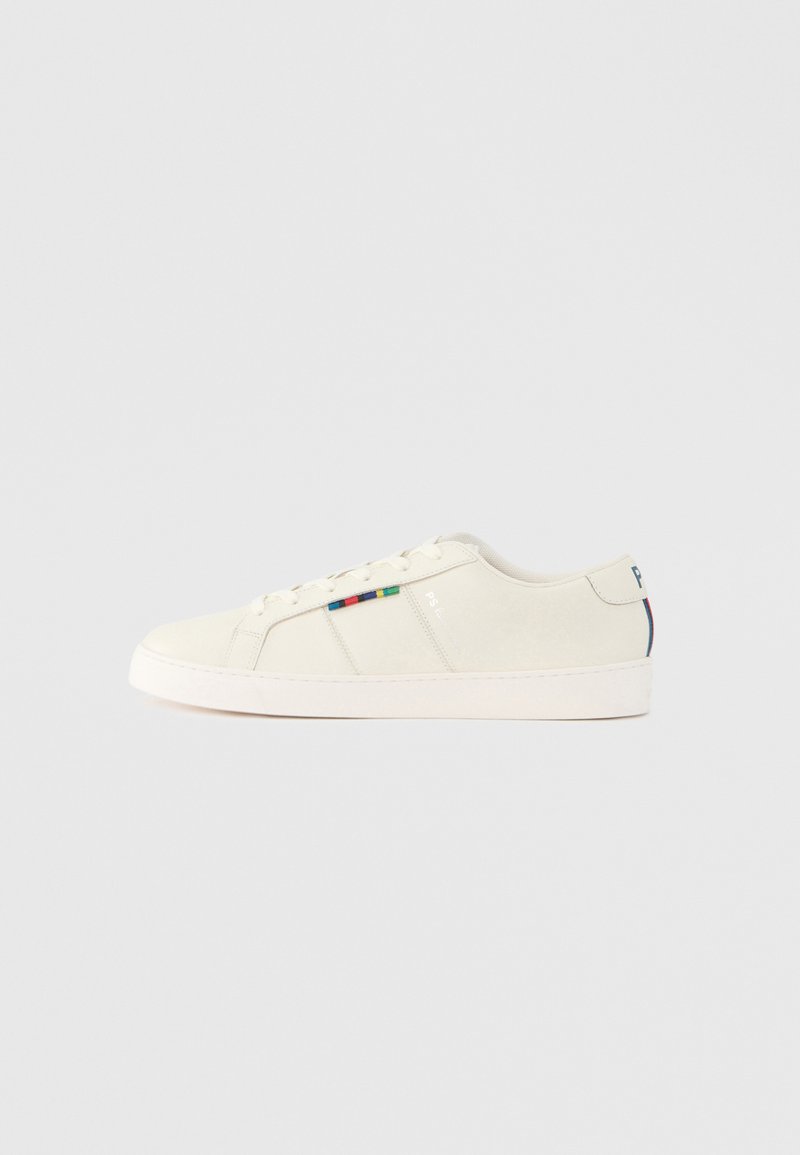 Svetlo béžové tenisky s hladkou textúrou, šnurovací dizajn a farebný pruhovaný akcent na boku. Biela gumová podrážka. Jednoduchý zadný diel.