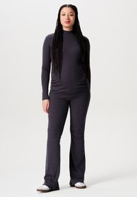 Dunkelgraues, geripptes Langarmoberteil und fließende Hose. Weicher Stoff, figurbetontes Design mit hohem Kragen und lockerer Passform an den Beinen.