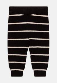 Pantaloni a maglia a righe bianche e nere con cintura a coste, gambe affusolate e texture morbida. Presentano righe orizzontali e una vestibilità aderente.