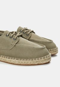 Olíva zöld vászon espadrille cipők, kerek orral, látható varrással, fűzős kialakítással és juta kötél talp részletekkel.
