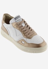 Baskets blanches et beiges avec un bout perforé, une tige en cuir texturé, des lacets plats, un logo sur la languette et une semelle en caoutchouc solide.