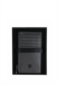 Porte-cartes en cuir noir dans une boîte, doté de six emplacements pour cartes, d'une finition texturée et d'un logo discret en bas. Un ruban en satin l'entoure.