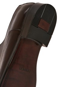 Semelle de chaussure en cuir brun avec une forme arrondie, dotée d'un talon en caoutchouc noir, d'une texture antidérapante et de détails de couture subtils.