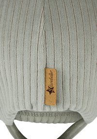Gray ribbed knit fabric with a small brown leather tag embossed with a star and the word "Sterntaler."