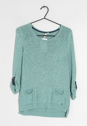 Lys grøn strikket sweater med scoop neckline, trekvartærmer, to forlommer og mørkeblå accenter ved ærmekanter.