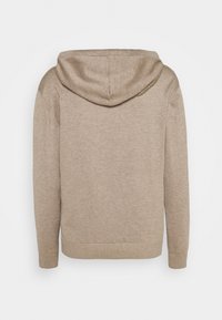 Beige stickad hoodie med långa ärmar och ribbade muddar, sedd bakifrån mot en vit bakgrund.