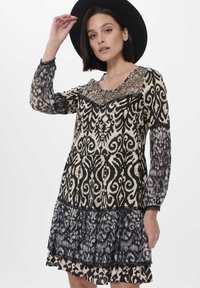 Schwarz-beiges gemustertes Kleid mit langen Spitzenärmeln, einem V-Ausschnitt und einem geschichteten Volantsaum. Verfügt über einen dekorativen Spitzenhalsausschnitt.