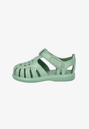 Sandalia de goma para niños de color verde claro con puntera cerrada, múltiples ranuras de ventilación y tira ajustable de velcro.