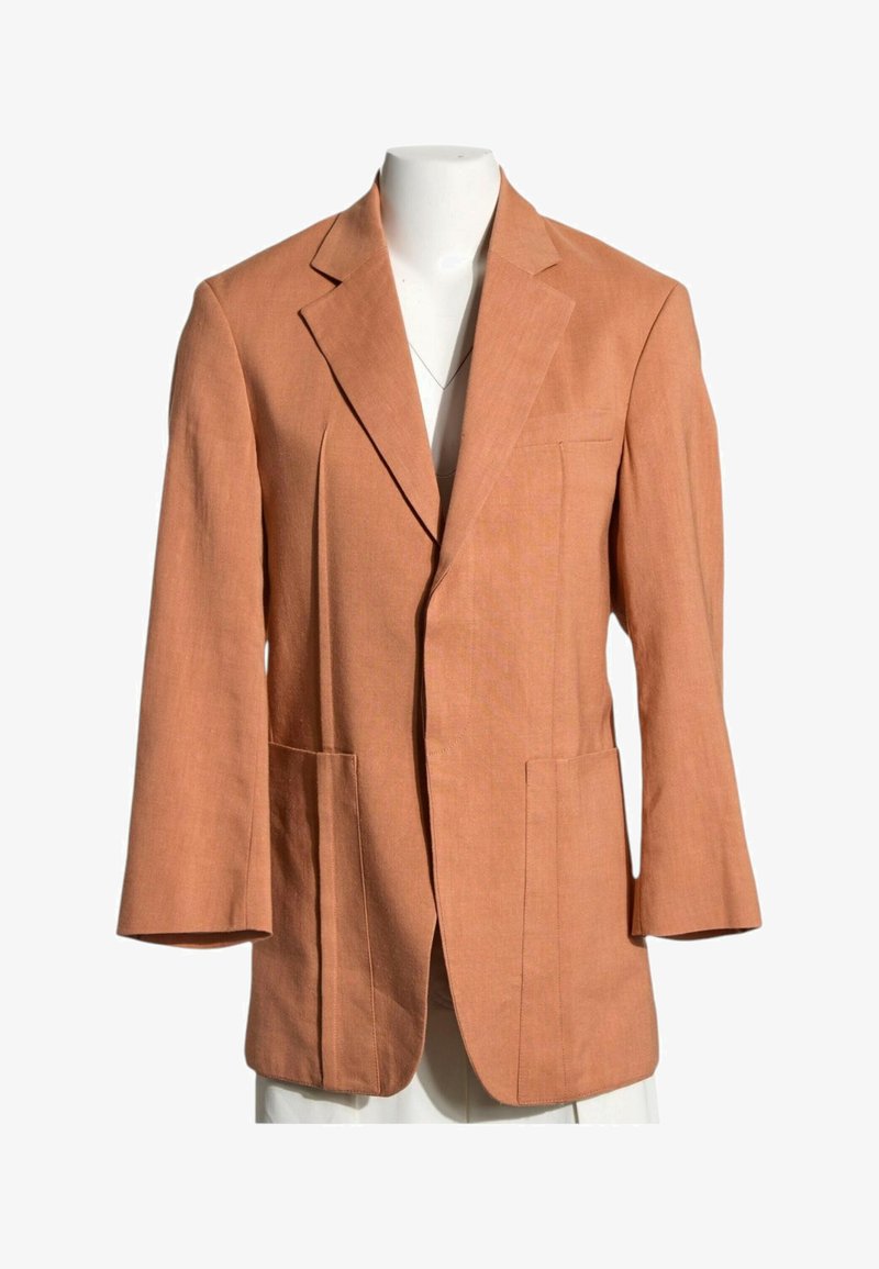 Veste à simple boutonnière marron clair avec revers crantés et trois poches avant présentée sur un mannequin blanc sans tête.