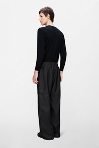 Μαύρο μακρυμάνικο πουκάμισο σε συνδυασμό με άνετο μαύρο παντελόνι με ελαστική μέση και πλαϊνές τσέπες. Ομαλή υφή υφάσματος.