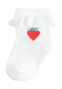 Vit ankelstrumpa med en rynkad spetskant och en röd jordgubbsdesign i mitten, med gröna blad och små svarta frön.