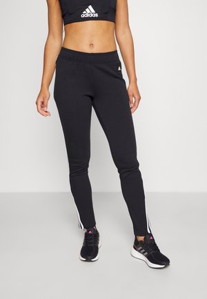 Pantalons de sport noirs avec une coupe fuselée, en matériau lisse. Présente des rayures latérales blanches et une taille élastique.