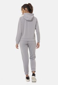 Hellgraues Hoodie- und Sweatpants-Set, aus weichem Stoff gefertigt, mit Kapuze, geribbelten Bündchen und lockerer Passform. Minimalistisches Design, keine Muster.