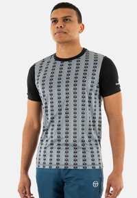 Camiseta de manga corta con un patrón de rayas en negro y gris que presenta logotipos circulares repetidos. Fabricada con tejido ligero, diseño sin costuras.