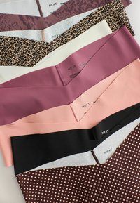 Six paires de sous-vêtements sans couture pour femmes, imprimés léopard, rose, mauve, noir et à pois, disposées en rangée.