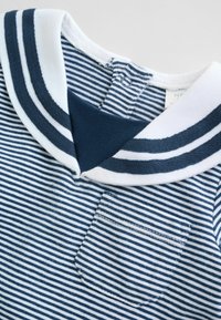 Blåt og hvidt stribet babyoutfit med lille brystlomme og sømandsskrave med blå striber samt lukning med trykknapper.