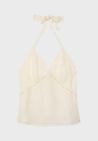 Kremasta majica na vezanje s valovitim čipkastim rubom i mašnom na vratu, ima V-izrez i mekan materijal.