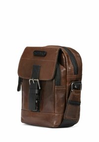 Brązowa skórzana torba na ramię z klapą, przednią kieszenią na zamek i regulowanym paskiem. Posiada matową czarną klamrę i teksturowane wykończenie.