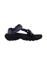 Sandales noires avec une semelle texturée, dotées de sangles en textile à motifs qui s'enroulent autour de la cheville et de l'orteil pour un maintien sûr.