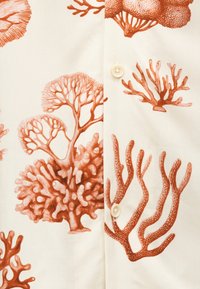 Skjorte med knappelukking som har en kremfarget bakgrunn med illustrasjoner av korall og tang i nyanser av rødbrunt. Myk tekstur, lett stoff.