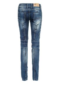 Jeans en denim bleu skinny avec un lavage décoloré, des détails de couture verticaux et deux poches arrière arborant un logo brodé.
