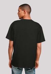 Black short-sleeve t-shirt with a round neckline and a relaxed fit. The fabric appears smooth, with a solid color and no visible patterns.