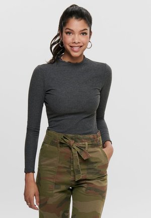 Gray ribbed long-sleeve top with a high neck, paired with green camouflage high-waisted cargo pants featuring a bow belt and side pockets.