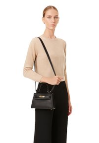 Borsa a mano in pelle nera con forma strutturata, dotata di manico superiore e tracolla staccabile. Hardware con finiture dorate.